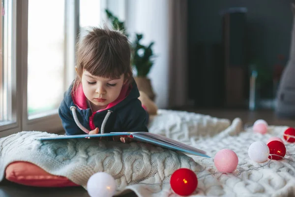 Nettes Kleines Mädchen Liest Ein Buch Das Auf Einer Wolldecke — Stockfoto