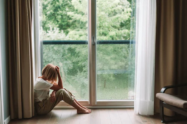 Depresyonda Olan Bir Kadın Yere Oturmuş Pencereden Bakıyor Yalnız Üzgün — Stok fotoğraf