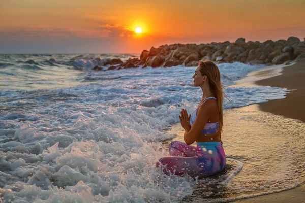 日没時にビーチの蓮の花の位置に座って閉じ目を持つ女性 内部の調和と自己のボディケア — ストック写真