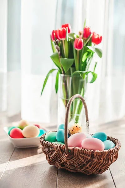 Ζυμαρικά Χρωματιστά Πασχαλινά Αυγά Ένα Καλάθι Τουλίπες Φόντο — Φωτογραφία Αρχείου