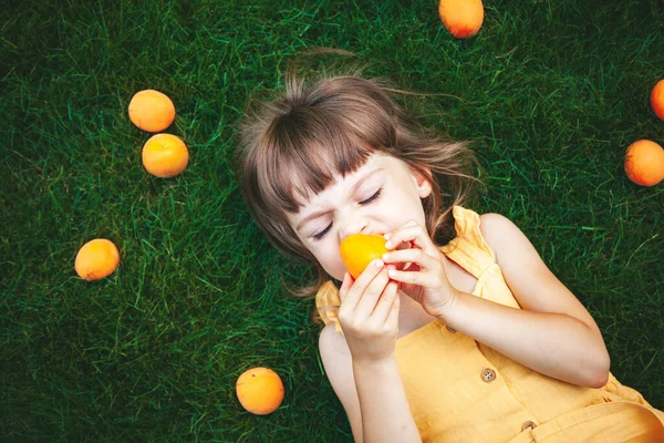 Niña Años Acostada Sobre Una Hierba Verde Disfrutando Comiendo Albaricoques —  Fotos de Stock