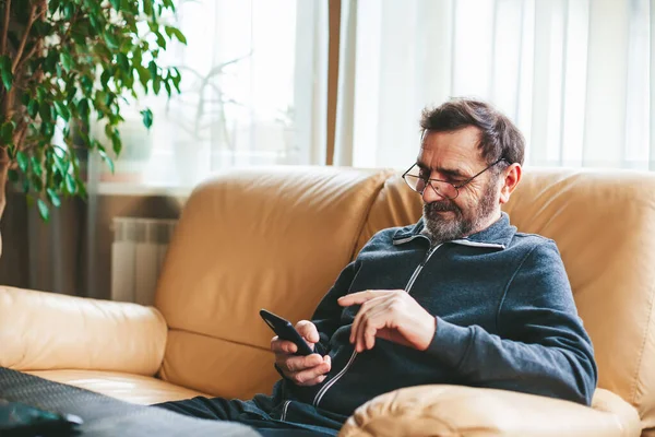 Smiling Matre Man Glass Sitting Sofa Texting Messaging Searching Reading — Stok Foto