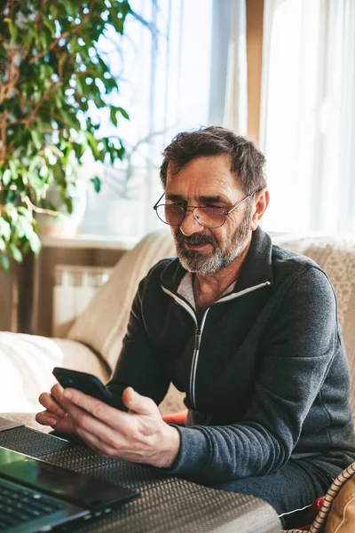 Hombre Maduro Con Gafas Sentado Sofá Enviando Mensajes Texto Mensajes —  Fotos de Stock