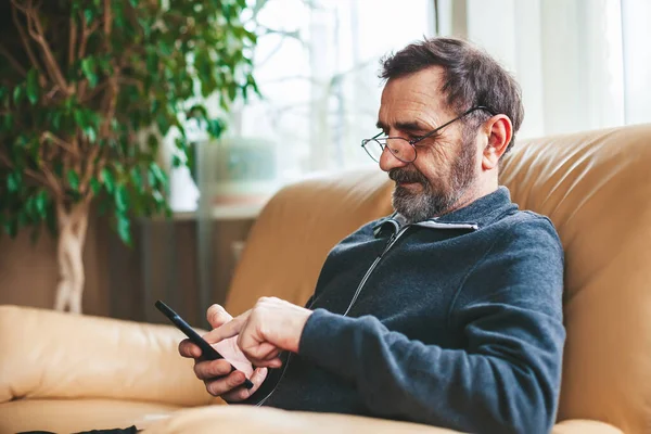 Volwassen Man Brillen Sms Zoeken Lezen Een Moderne Smartphone Senioren Rechtenvrije Stockfoto's