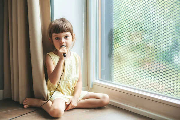 Menina Bonito Com Microfone Cantando Casa Sentado Chão Perto Janela — Fotografia de Stock