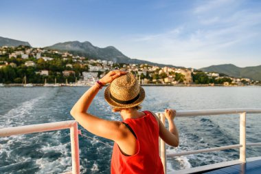Hasır şapkalı bir kadının Herceg Novi kasabası, Kotor Körfezi, Karadağ ve Avrupa 'daki denize ve dağlara bakışının arkası 