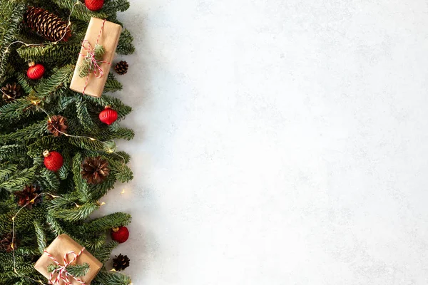 Christmas postcard with fir branches, pine cones and gift boxes on a white background. Holiday background card with copy-space. Merry Christmas and Happy New Year!