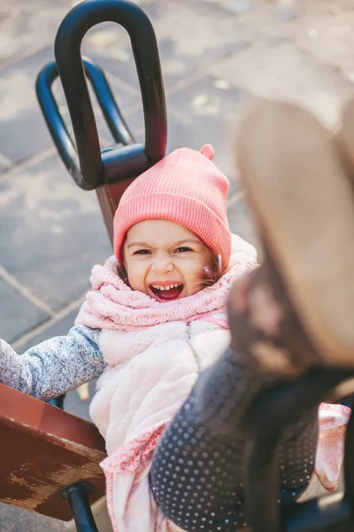 かわいい笑いの女の子は遊び場でスイングするのが好き — ストック写真