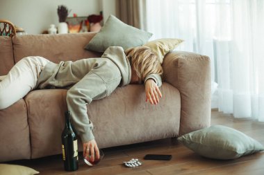 Bir bardak viskisi olan, baş ağrısından muzdarip sarhoş bir genç kadın bir vagonda yatıyor. Alkolik, sosyal sorun, stres, bağımlılık ve yalnızlık kavramı.