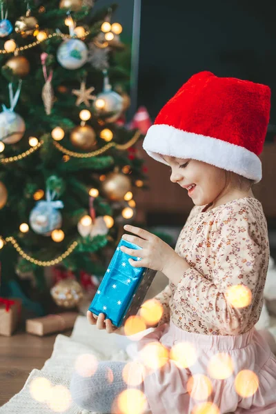 Smiling Cute Little Girl Red Santa Claus Hat Opening Gift — Stock Photo, Image