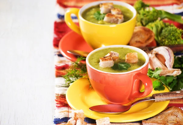 Two cheerful cup with green broccoli soup — Stock Photo, Image