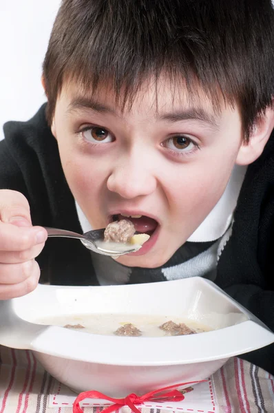 Der Junge isst die Suppe mit Frikadellen — Stockfoto