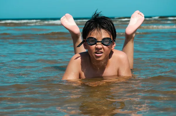 Boy swims in the sea with glasses for swimming — Stock Photo, Image