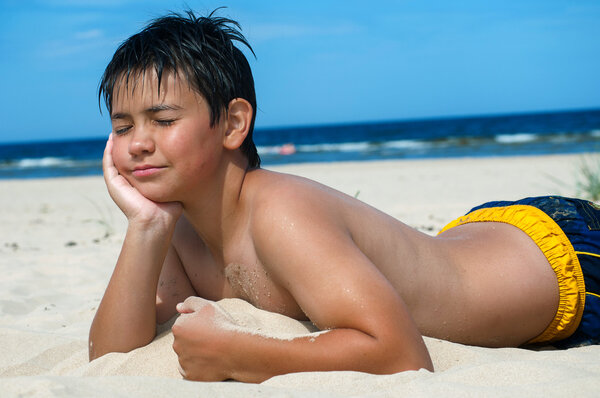 Boy lying on the beach
