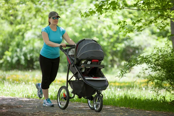 Jonge vrouw met een wandelwagen Stockfoto