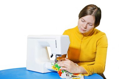 Woman working at the sewing machine clipart
