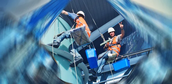 Un hombre limpiando ventanas en un edificio alto —  Fotos de Stock