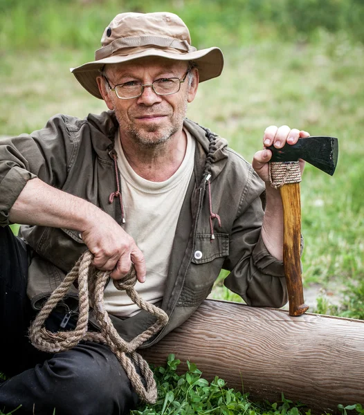 Senior tourist man with axe — Stock Photo, Image