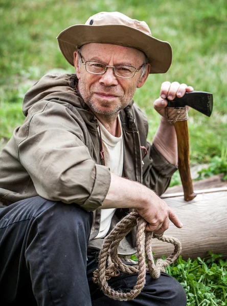 Senior tourist man with axe — Stock Photo, Image