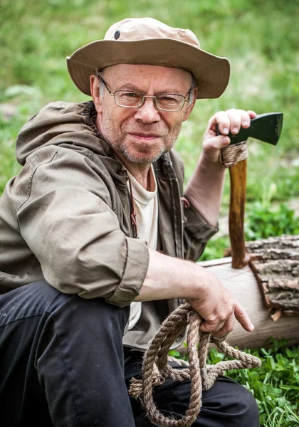 Senior tourist man with axe — Stock Photo, Image