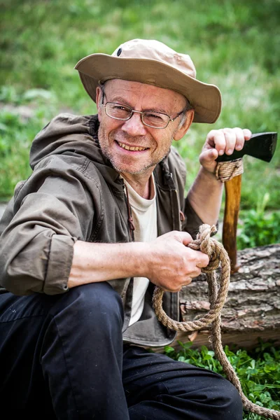 Senior tourist man with axe — Stock Photo, Image