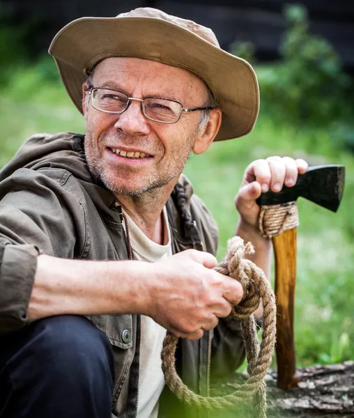 Senior tourist man with axe — Stock Photo, Image