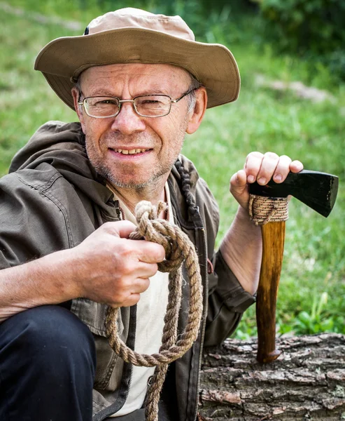 Senior tourist man with axe — Stock Photo, Image