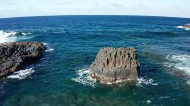 Atlantik Okyanusu 'ndaki küçük bazalt sütunları çevreleyen hava yayı, El Hierro, Kanarya Adaları' ndaki Pozo de Las Calcosas adlı terk edilmiş balıkçı köyünün arka planında dalgalar oluşturdu.