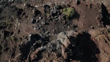 Dikey olarak aşağı doğru kayan volkanik kayalık kıyısı uçurumun kenarından yükselen Atlantik Okyanusu 'na doğru El Hierro adasının kara kumları ve kayaları üzerinde uçuyor.