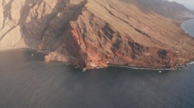 Atlantik kıyı şeridinin üzerinde, El Hierro adasının yamacındaki Atlantik Okyanusu 'nda sabah güneşiyle birlikte Kanarya Adaları' nın gölgesinde kalan Roque de La Bonanza şehir simgesi yakınındaki hava kayması.