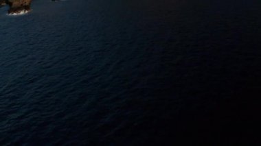 Koyu mavi okyanustan, İspanya 'nın Kanarya Adaları' ndaki El Hierro Adası 'nın Verodal plajına bakan paslı kahverengi volkanik kıyı manzarasına doğru uçan hava aracı.