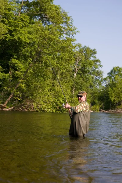 Fischer zieht gefangenen Lachs. — Stockfoto