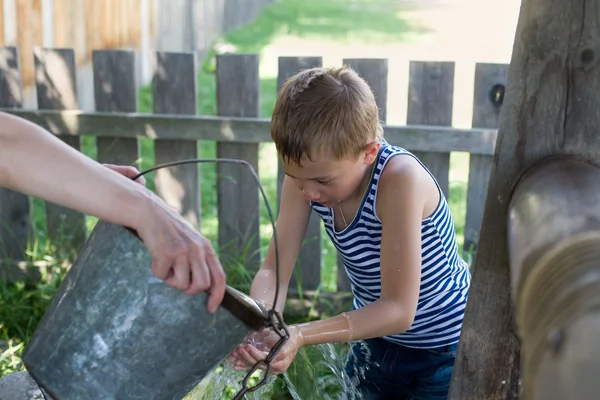 Junge wäscht Brunnenwasser. — Stockfoto