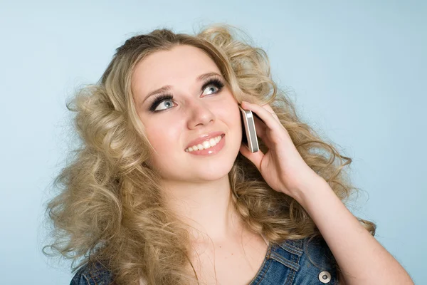 Blond meisje eist met een mobiele telefoon. — Stockfoto