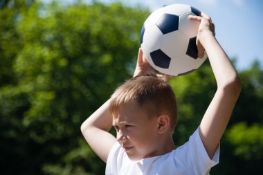 Çocuk topu fırlatıyor.