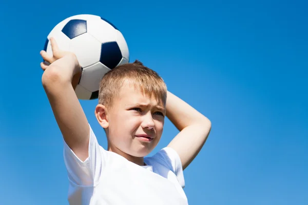 Pojken kastar en boll för fotboll. — Stockfoto