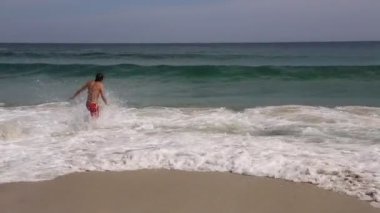 genç adam denize yüzmeye.