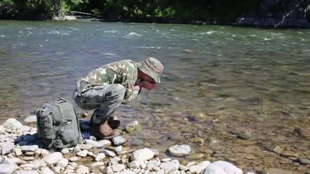 Hiker dricksvatten från floden i händerna. — Stockvideo