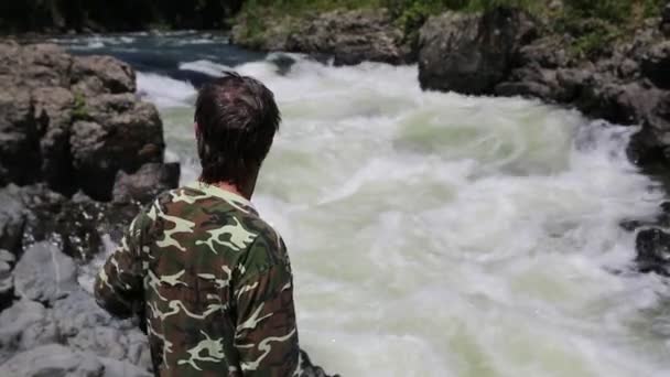 Hiker tittar på rasande torrent av floden berg — Stockvideo