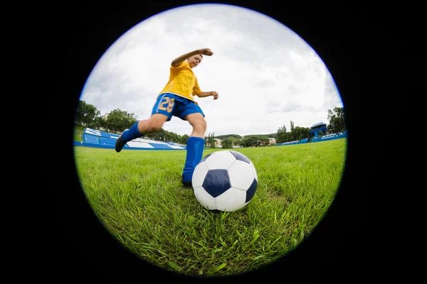 Menino jogador de futebol bate a bola — Fotografia de Stock