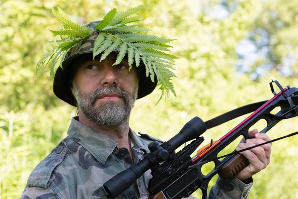 Jägare håller ett armborst — Stockfoto