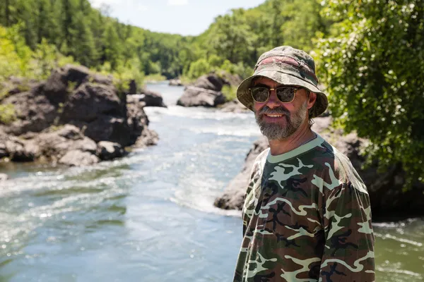 Voyageur souriant debout au bord de la rivière — Photo