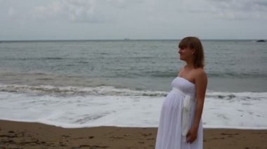 mutlu hamile kadın ve kocası sahil üzerinde.