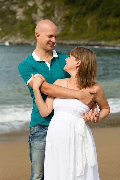 Schwangere und ihr Mann spazieren am Meer. — Stockfoto