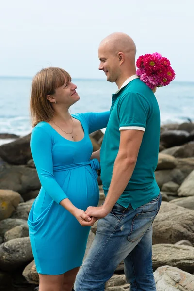 Happy pregnant woman and her husband on the coast. — Stock Photo, Image