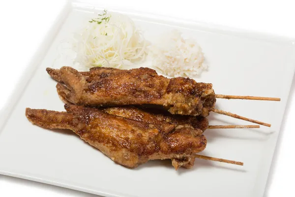Fried chicken wings with sauce on skewers with rice — Stock Photo, Image