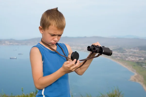 Dağın tepesinde dürbünlü çocuk uzun yürüyüşe çıkan kimse. — Stok fotoğraf