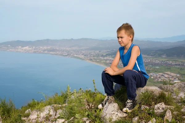 Boy traveler on top of a mountain. — Stock Photo, Image