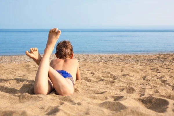 Niño feliz acostado en la playa —  Fotos de Stock