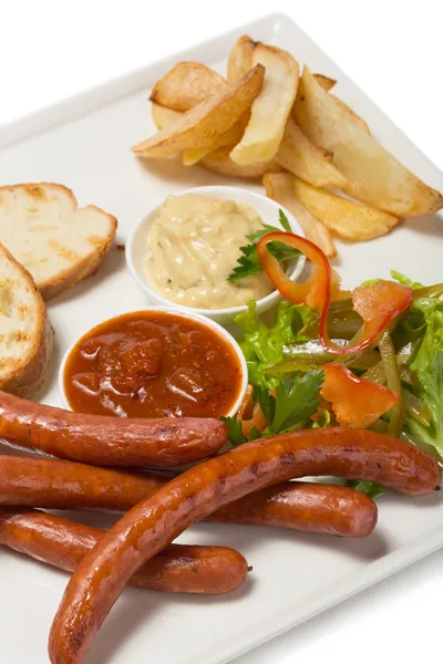 Spicy smoked sausage with cheese and fry potatoes in a pan. — Stock Photo, Image